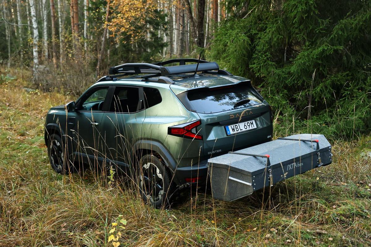 Dacia Duster met een gemonteerde IXTAbox trekhaakbox, geparkeerd op een bospad